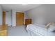 Bedroom with gray walls, carpeted floors, closet with wooden sliding doors, and neutral bedding at 15120 Romalong Ln, Carmel, IN 46032
