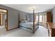 Bedroom showcasing carpet, gray walls, a four-poster bed, and natural light at 15120 Romalong Ln, Carmel, IN 46032
