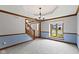 Inviting entryway featuring a bright window, staircase, and modern chandelier at 15120 Romalong Ln, Carmel, IN 46032