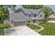 Aerial view of a well-manicured two-story home with a large driveway and lush lawn at 15120 Romalong Ln, Carmel, IN 46032
