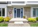 Inviting entrance with a blue door, brick surround, decorative wreath, and manicured landscaping at 15120 Romalong Ln, Carmel, IN 46032