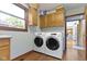 Laundry area featuring a washer and dryer, wood cabinets, and wood-look floors at 15120 Romalong Ln, Carmel, IN 46032