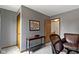 Cozy office space with gray walls, a wooden desk, comfortable chair, and an open doorway to the hallway at 15120 Romalong Ln, Carmel, IN 46032