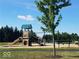 Community playground with slide, swings, and bench seating under a sunny sky at 15120 Romalong Ln, Carmel, IN 46032