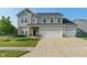 Traditional two-story home with gray siding, brick accents, well-manicured lawn, and a three-car garage at 15736 Conductors Dr, Westfield, IN 46074