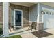View of front door with two ornate chairs and brick accents at 15736 Conductors Dr, Westfield, IN 46074