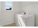 Clean laundry room featuring a washing machine, dryer, and a shelf for storing laundry essentials at 15736 Conductors Dr, Westfield, IN 46074
