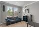 Cozy living room with a black leather sofa, TV, and natural light from two windows at 15736 Conductors Dr, Westfield, IN 46074