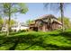 Sprawling backyard with healthy lawn, mature trees, and elegant brick home with spacious deck at 16307 Stony Ridge Dr, Noblesville, IN 46060