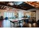 A finished basement with a ping pong table, string lights, and exposed ceiling beams, perfect for entertaining at 16307 Stony Ridge Dr, Noblesville, IN 46060