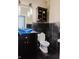 Contemporary bathroom featuring unique blue bowl sink, dark cabinetry, and contrasting dark tiled walls at 16307 Stony Ridge Dr, Noblesville, IN 46060