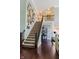 A grand foyer featuring hardwood floors, carpeted stairs, and an open view to the living area above at 16307 Stony Ridge Dr, Noblesville, IN 46060