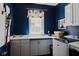 Well-organized laundry room with ample cabinet space, modern washer and dryer, and stylish blue walls at 16307 Stony Ridge Dr, Noblesville, IN 46060