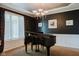 Elegant living room featuring a grand piano, dark walls, and modern lighting at 16307 Stony Ridge Dr, Noblesville, IN 46060