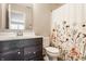 Stylish bathroom with a dark vanity, floral shower curtain, and bright lighting offering a comfortable space at 16310 Nightshore Ln, Fishers, IN 46037