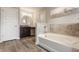 Bright bathroom with a soaking tub, dark vanity, and brushed nickel fixtures creates a spa-like experience at 16310 Nightshore Ln, Fishers, IN 46037