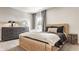 Modern bedroom with light wood bed frame, dark dresser, and a bright window creating a serene retreat at 16310 Nightshore Ln, Fishers, IN 46037