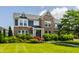 Charming two-story brick home with a well-manicured lawn and lush landscaping at 16310 Nightshore Ln, Fishers, IN 46037