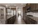 Well-lit kitchen featuring dark cabinets, granite countertops, stainless steel appliances, and hardwood floors at 16310 Nightshore Ln, Fishers, IN 46037