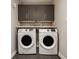 Laundry room features white washer and dryer, upper cabinets and gray tile backsplash at 16310 Nightshore Ln, Fishers, IN 46037