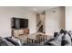 Open-concept living room with stairs, TV, and large gray sectional sofa at 16310 Nightshore Ln, Fishers, IN 46037