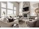 Cozy living room featuring a floor-to-ceiling stone fireplace, large windows, and stylish furniture at 16310 Nightshore Ln, Fishers, IN 46037