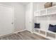 Mudroom with white storage and bench area, with hooks for hanging, next to exterior door at 16310 Nightshore Ln, Fishers, IN 46037