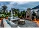 Charming patio with stone fireplace, comfortable seating, and a beautifully landscaped backyard for outdoor entertaining at 16310 Nightshore Ln, Fishers, IN 46037