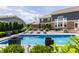 Stunning backyard pool with fountains, complemented by lounge chairs and lush landscaping at 16310 Nightshore Ln, Fishers, IN 46037