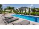 Backyard pool features fountains and nearby lounge chairs; manicured landscaping visible at 16310 Nightshore Ln, Fishers, IN 46037