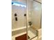 Close-up of a modern shower with glass doors, tiled walls, and a built-in seat at 17324 Americana Crossing Xing, Noblesville, IN 46060
