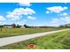 Expansive green pasture with a white barn under a bright blue sky and some scattered trees and an access road at 17324 Americana Xing, Noblesville, IN 46060