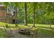 Expansive backyard with a fire pit and trampoline, framed by a home and dense trees, perfect for outdoor activities at 2034 Dynasty Ridge Rd, Martinsville, IN 46151