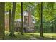 Beautiful backyard of a brick home, surrounded by lush trees and greenery, seen through the woods at 2034 Dynasty Ridge Rd, Martinsville, IN 46151