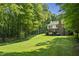 Expansive backyard with lush lawn, surrounded by mature trees, showcasing a serene outdoor space and house at 2034 Dynasty Ridge Rd, Martinsville, IN 46151