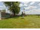 Lush backyard featuring mature trees, a deck, and a charming playset, ideal for relaxing and outdoor enjoyment at 2170 N Old State Road 9, Columbus, IN 47203