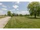 Expansive green backyard with a gravel area, bordered by mature trees and a distant basketball hoop at 2170 N Old State Road 9, Columbus, IN 47203