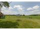 Spacious backyard with a playset and view of a field beyond the property line, perfect for outdoor adventures at 2170 N Old State Road 9, Columbus, IN 47203