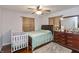 Bedroom with hardwood floors, curtains, ceiling fan, and a dresser with a mirror at 2170 N Old State Road 9, Columbus, IN 47203