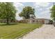 Inviting single-story brick home with a spacious, well-kept lawn, gravel driveway and convenient attached garage at 2170 N Old State Road 9, Columbus, IN 47203