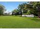 Expansive backyard with lush green grass and mature trees including a detached garage at 227 Vestal Rd, Plainfield, IN 46168