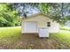 View of a detached one-car garage in a backyard featuring light yellow siding and a white garage door at 227 Vestal Rd, Plainfield, IN 46168