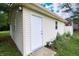 View of the side of a detached one-car garage featuring light yellow siding and a white entry door at 227 Vestal Rd, Plainfield, IN 46168