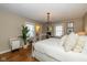 Bright bedroom with hardwood floors, neutral walls, and a view into the ensuite bathroom at 253 W Westfield Blvd, Indianapolis, IN 46208