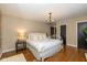 Cozy bedroom with white metal frame bed, hardwood floors, and elegant chandelier lighting at 253 W Westfield Blvd, Indianapolis, IN 46208
