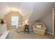 Cozy sitting area with sloped ceilings, comfortable chairs, and natural light from a window at 253 W Westfield Blvd, Indianapolis, IN 46208