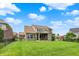 Expansive backyard featuring lush green grass, a covered patio, and mature landscaping at 2715 Benmore Ct, Zionsville, IN 46077