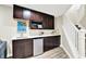 Basement wet bar area features dark wood cabinets, a mini fridge and a white countertop at 2715 Benmore Ct, Zionsville, IN 46077