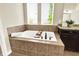 This bathroom has a jacuzzi tub, tile surround, dark cabinets and granite countertop at 2715 Benmore Ct, Zionsville, IN 46077