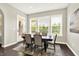 Bright dining room with wood floors, large windows, and a stylish table set for six, offering a perfect space for entertaining at 2715 Benmore Ct, Zionsville, IN 46077